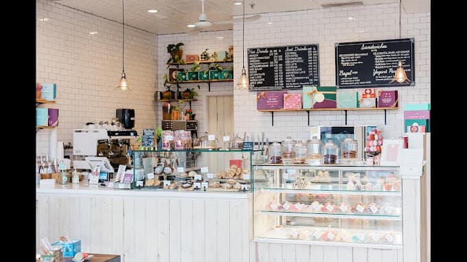 Counter of Woops! Bakeshop and a display case. Both showcasing different types of pastries. Menus hanging on back wall, with gift wrap options under them.
