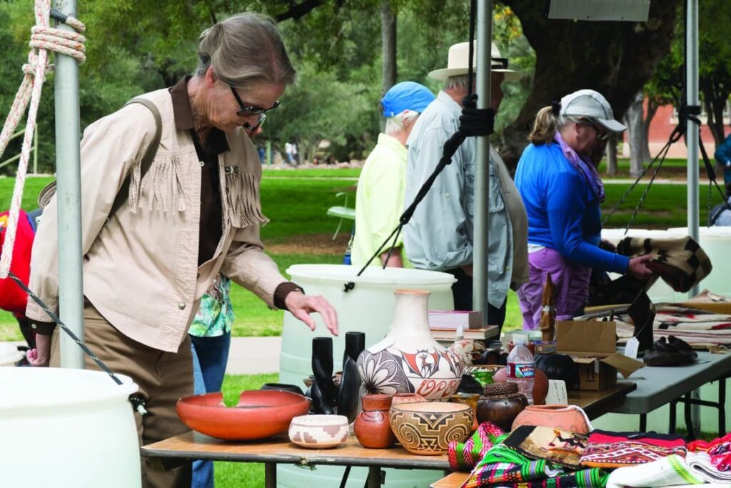 A woman browsing pottery on a table