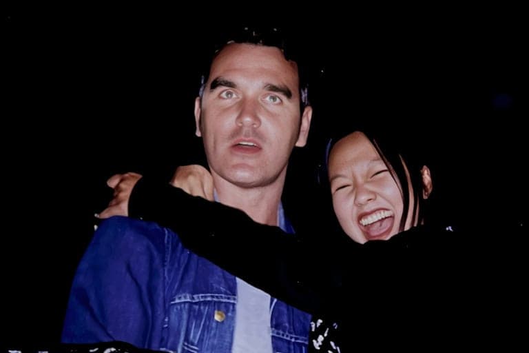 Man standing w/ woman arms around him